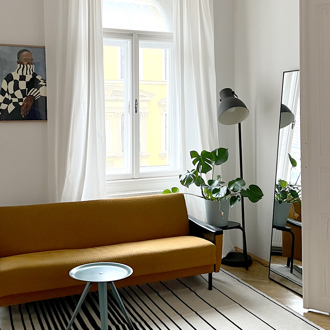 Helle Sitzecke im Kreativstudio in Wien mit Sofa, Pflanzen und großen Altbau-Fenstern – Location für DIY-Workshops und Junggesellinnenabschiede. | we love handmade