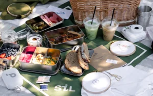 Picknickdecke im Burggarten mit SiL Tischtuch, Speisen in Edelstahldosen, Musikbox, Stickgarnen, Stickrahmen und Stick-Workbook