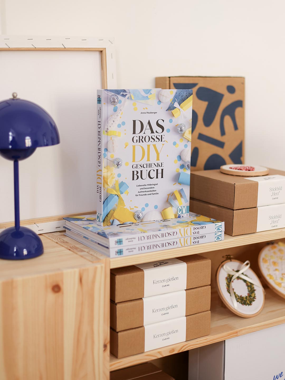 Das große DIY Geschenkebuch und gestapelte Craft Kits für Kerzen gießen und Stickbilder auf einem Holzregal