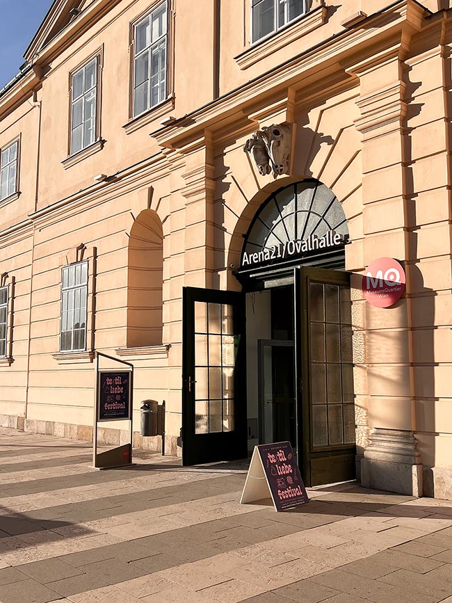 Eingang zur Arena21 und Ovalhalle im MuseumsQuartier Wien mit Aufstellern des Textilliebe Festivals in der Sonne